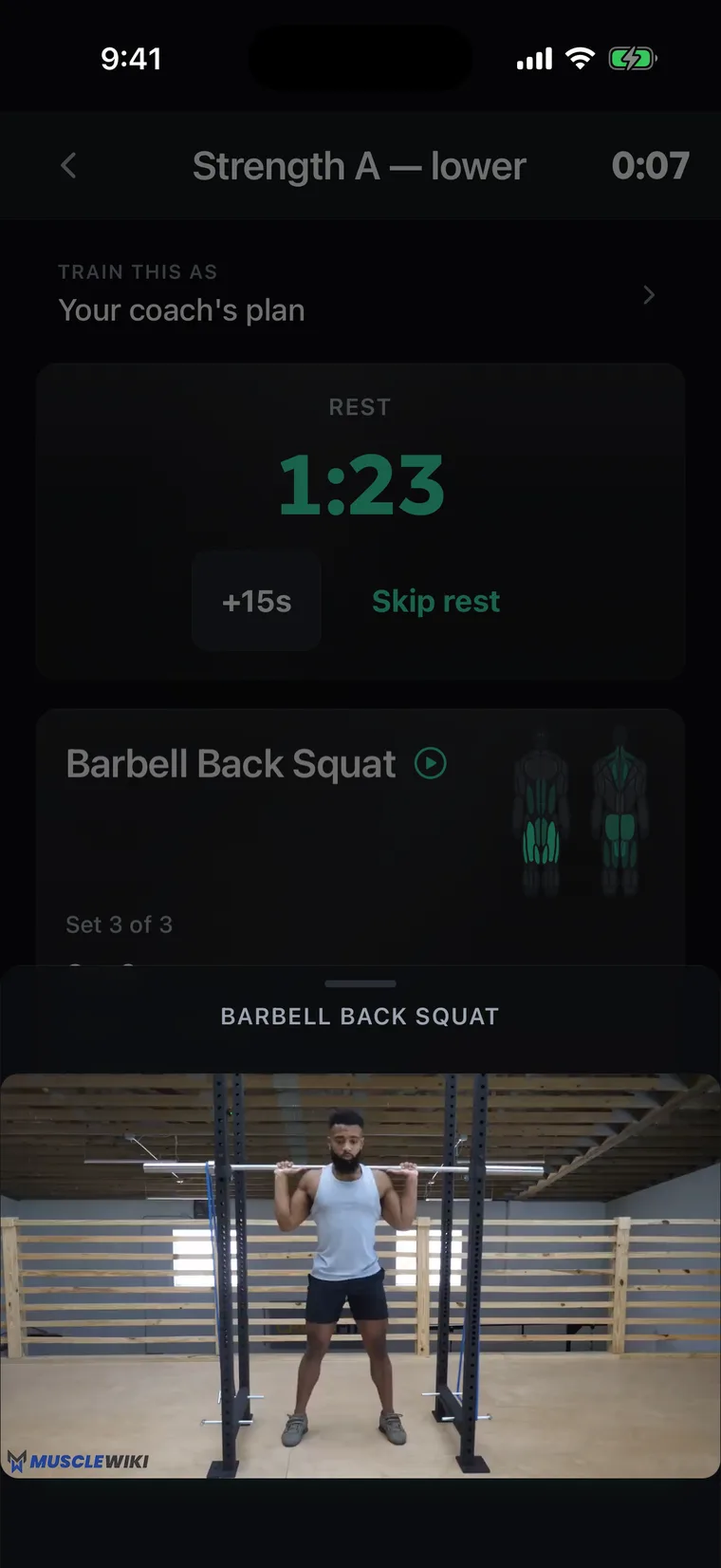 The Niru workout player mid-session: the rest timer counting down after a logged set of barbell back squats, with the movement's demo video open below it.